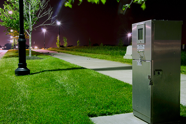 A Milbank pedestal provides power distribution to outdoor lighting near a park.