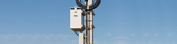 A pole with wires and a box attached for small cell capabilities.