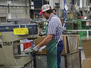 A Milbank plant employee works on bending metal for an enclosure.